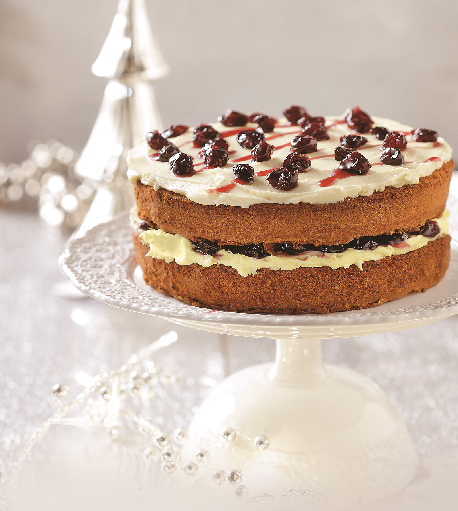 Τούρτα με αφράτο κέικ λεμονιού και γλάσο λευκής σοκολάτας με γλυκό βύσσινο