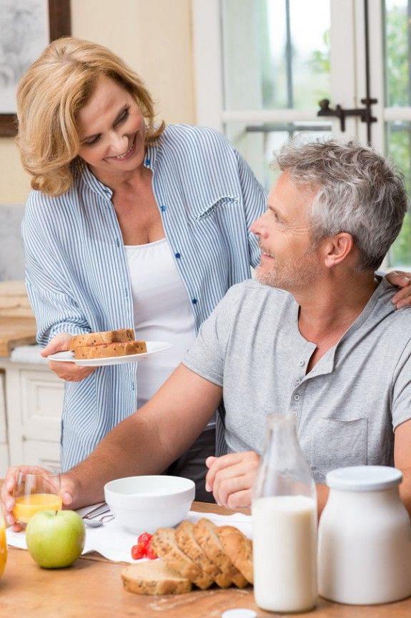 31178958 – smiling woman serves breakfast to her husband in morning