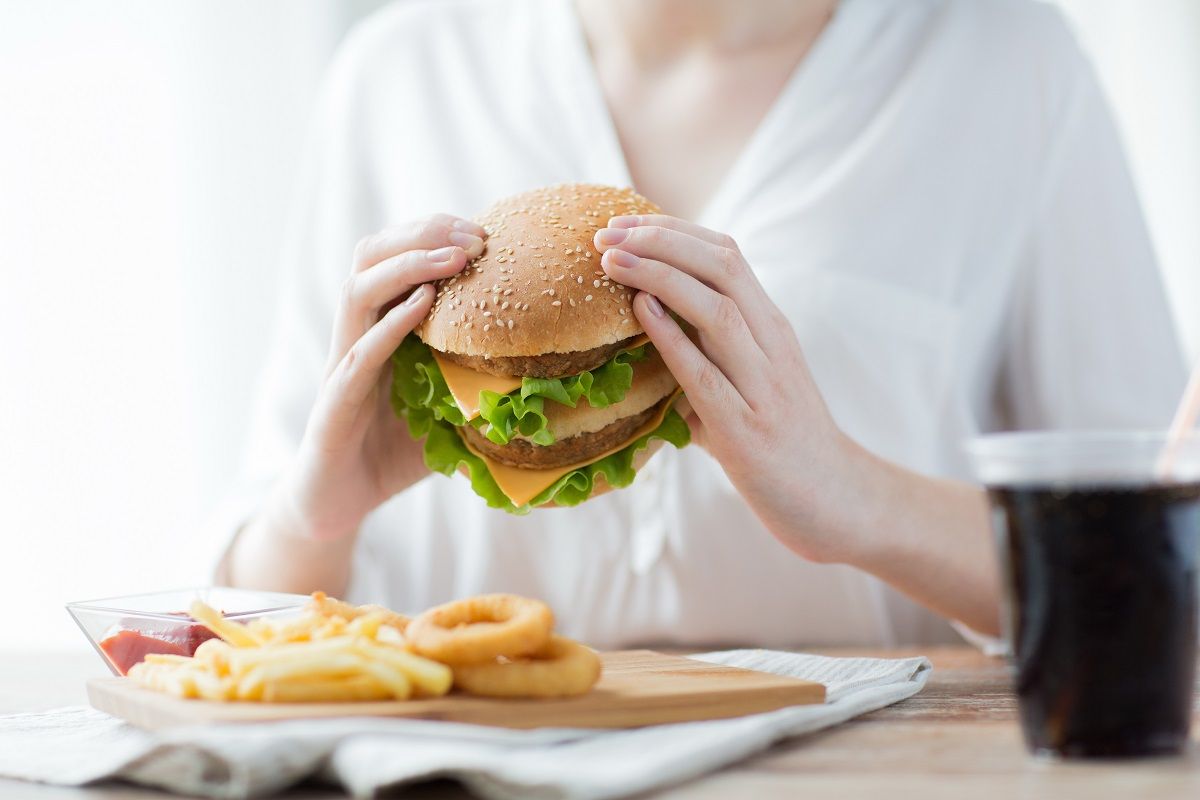 close up of woman hands holding hamburger