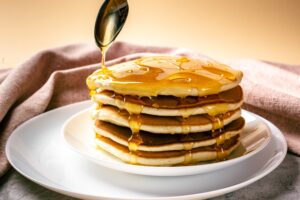 Pancakes.,Tall,Pile,Of,Delicious,Pancakes,With,Honey,Or,Maple