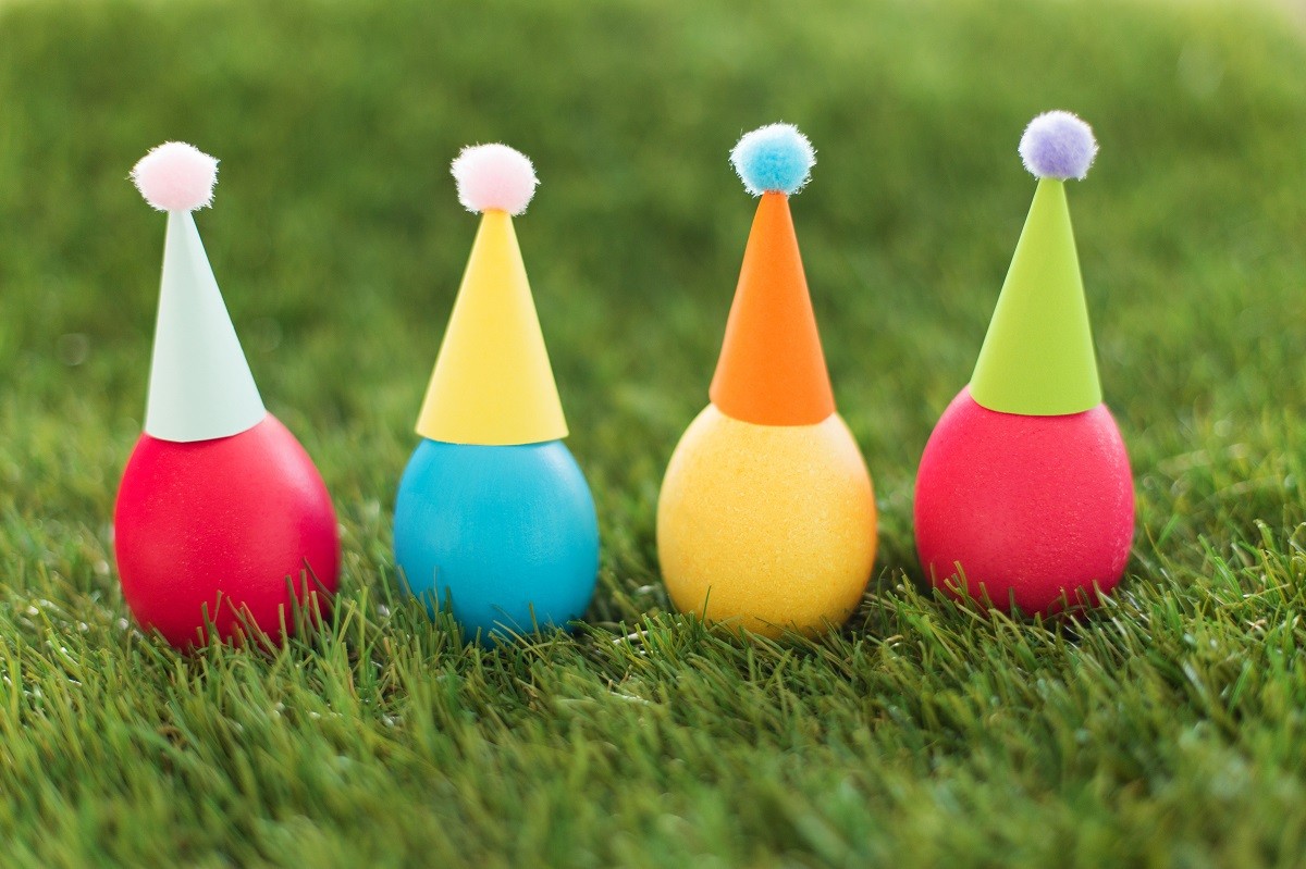 easter eggs in party hats on artificial grass