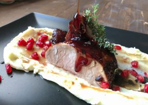 Pork tenderloin on mashed potatoes and pomegranate sauce