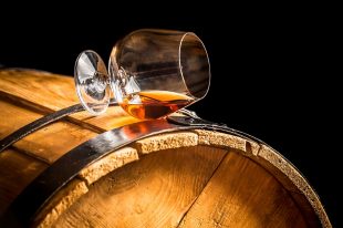 26122709 – glass of cognac on the vintage barrel