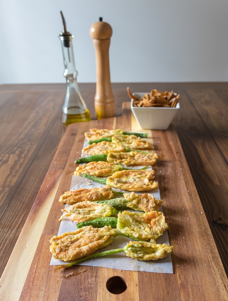 Fried zucchini squash courgette flowers on a wooden table