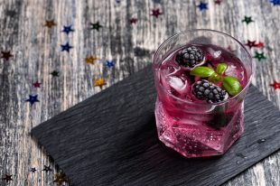 Sparkling alcoholic cocktail with a blackberry and basil