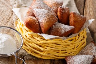 Deep fried African Mandazi donuts with powdered sugar close up o