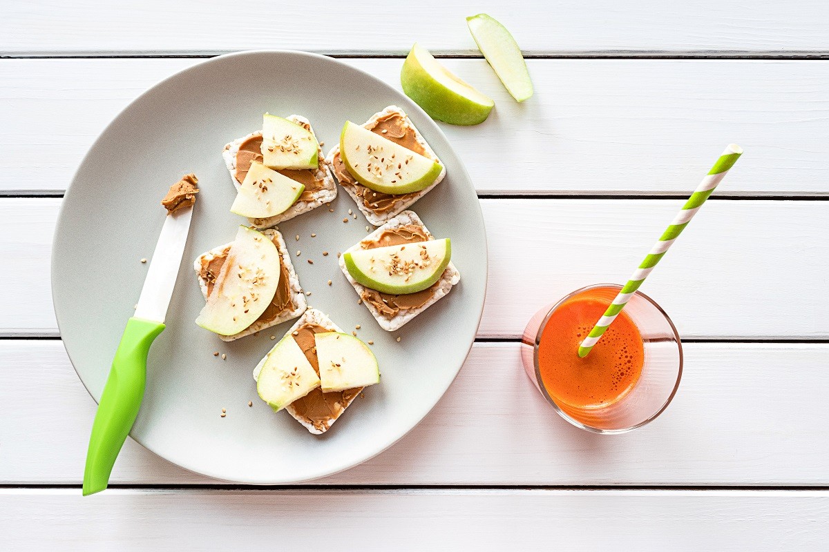 Healthy breakfast with peanut butter and apple sandwiches on rice cakes