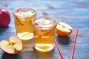 Glasses of tasty cold ice tea on color wooden background