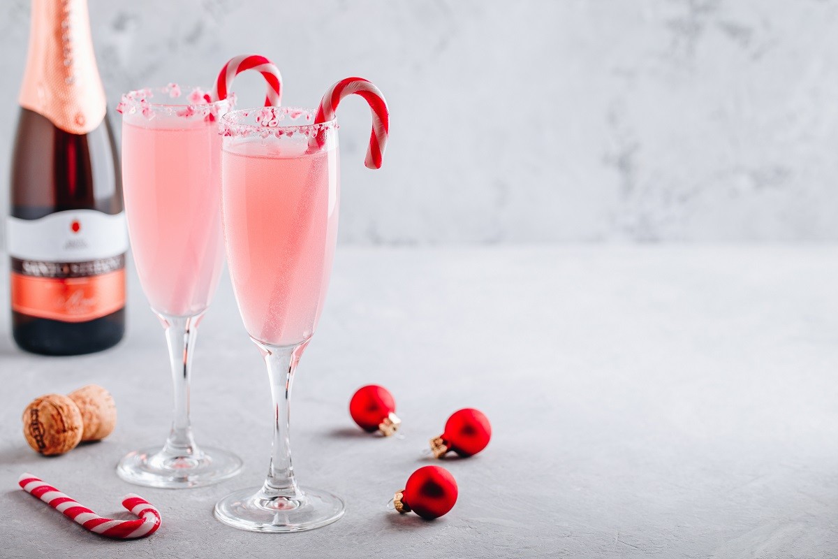 Festive Christmas drink Peppermint Bark Mimosa cocktail with champagne or prosecco and candy cane