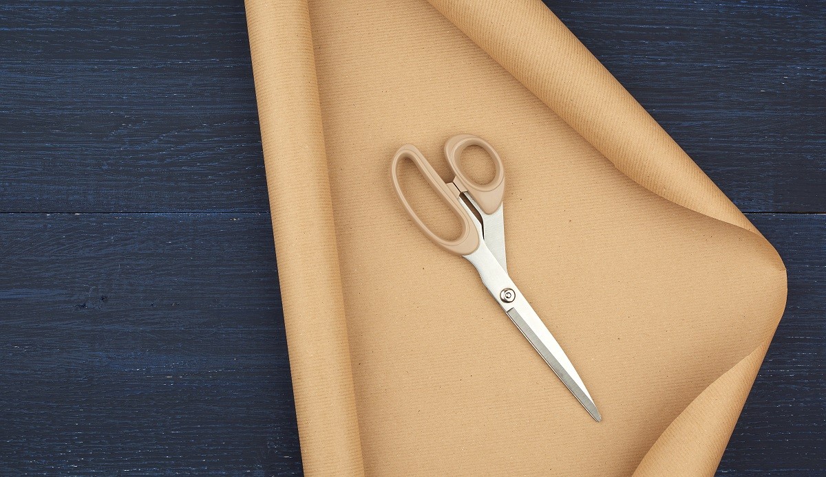 untwisted roll of brown craft paper on a blue wooden background