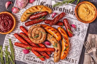 Homemade sausages grilled on a newspaper.