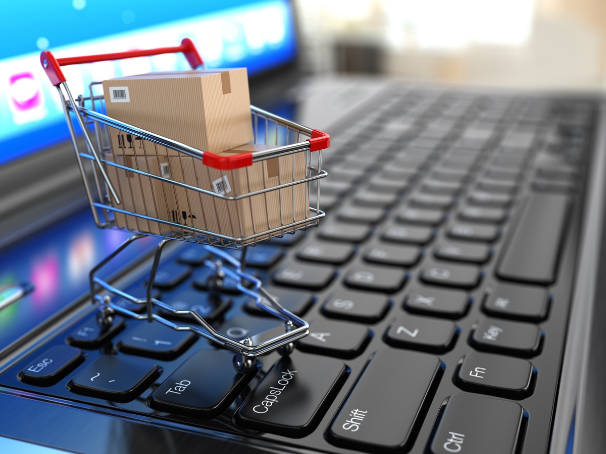 E-commerce.,Shopping,Cart,With,Cardboard,Boxes,On,Laptop.,3d