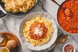 Plate,Of,Fresh,Tagliatelle,Pasta,With,Bolognese,Sauce,And,Bowl