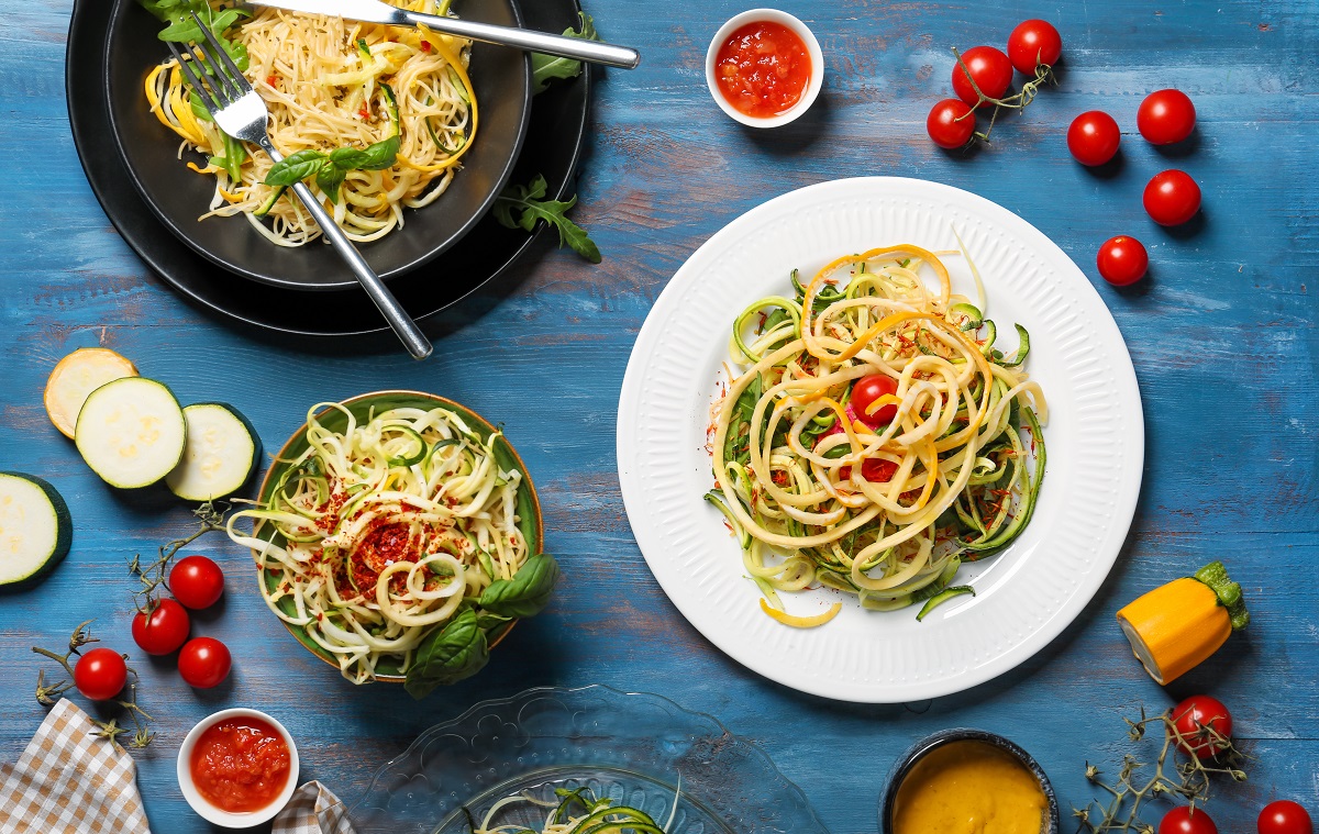 Tasty,Spaghetti,With,Zucchini,And,Sauces,On,Color,Wooden,Table