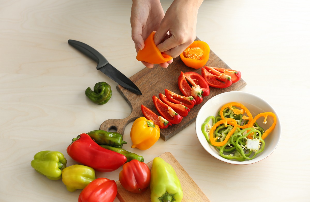 Woman,Preparing,Peppers,In,Kitchen