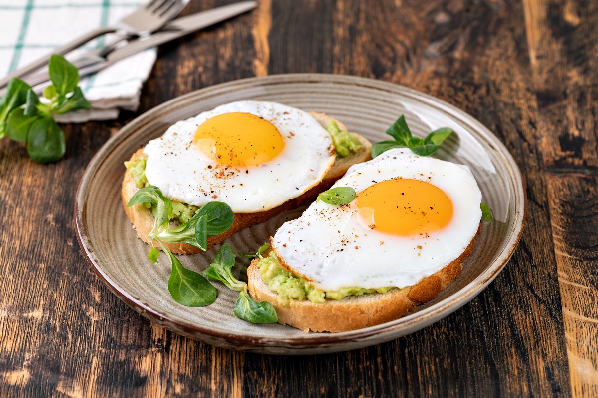 Toast,With,Fried,Egg,On,A,Wooden,Table