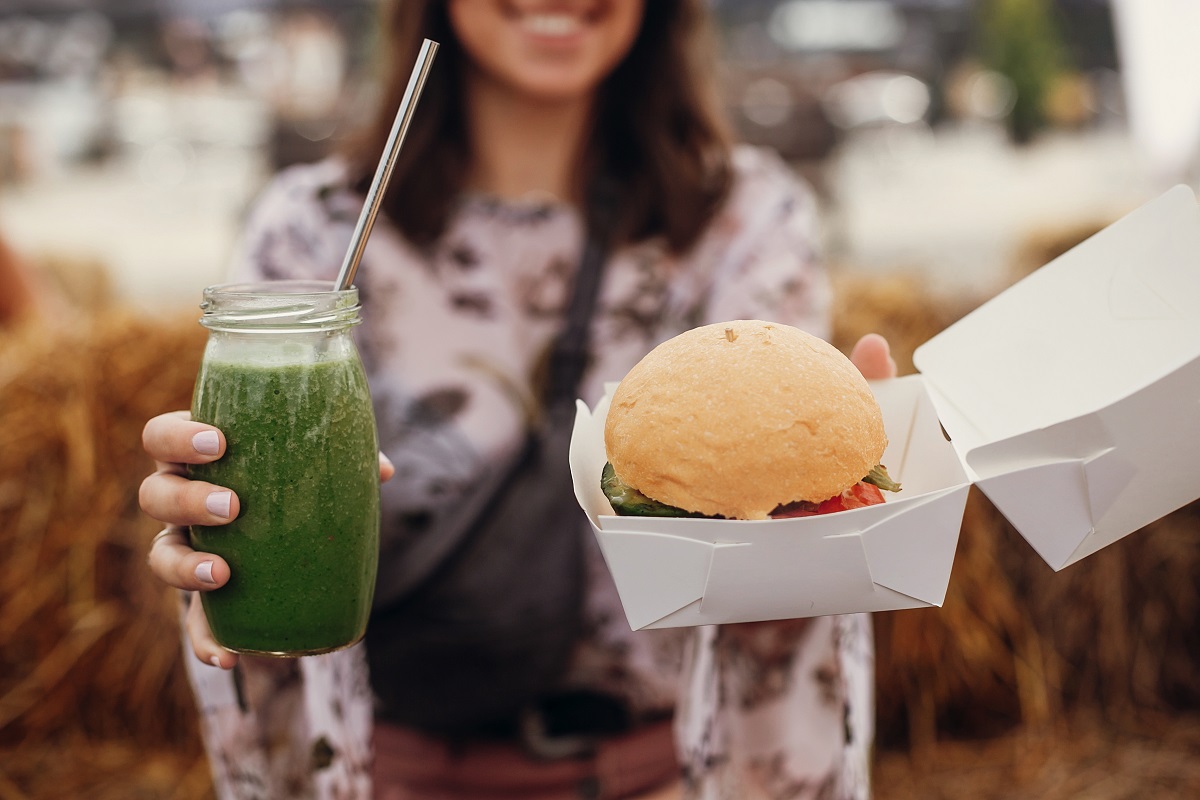 Stylish,Hipster,Girl,Holding,Delicious,Vegan,Burger,And,Smoothie,In