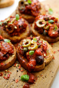 Crostini,With,Roasted,Tomato,Sauce,,Olives,,Capers,And,Herbs