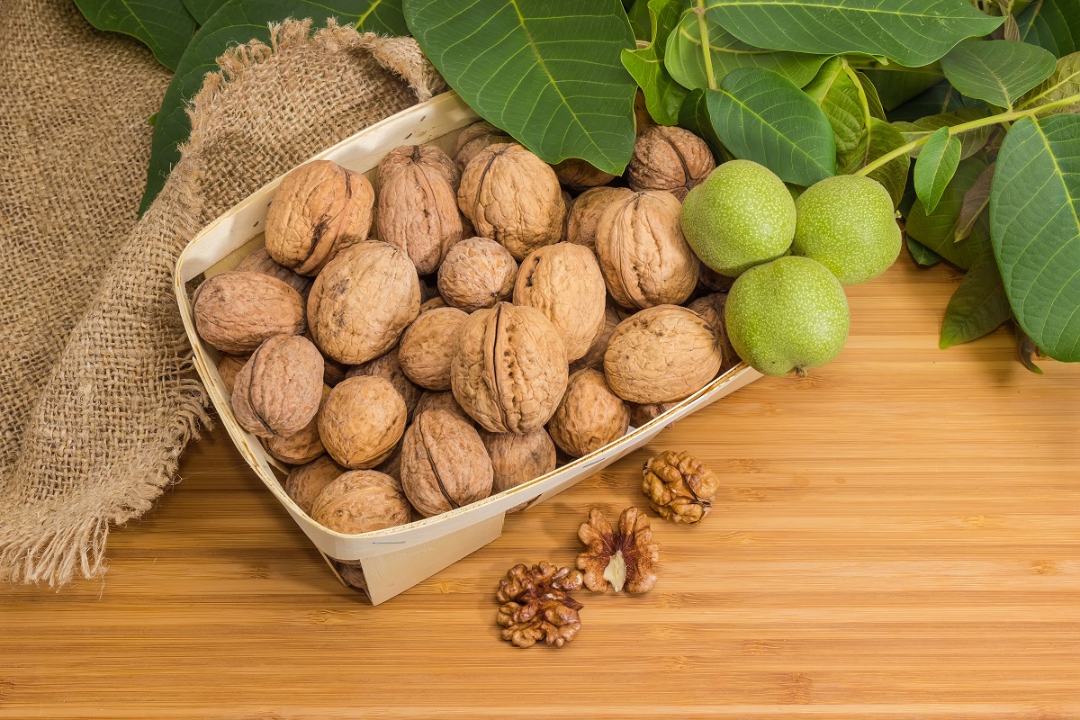 Ripe,Whole,Walnut,Fruits,In,Small,Wooden,Basket,,Husked,Nut
