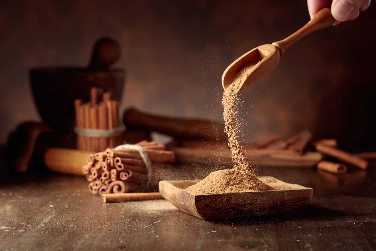 Cinnamon,Powder,Is,Poured,Into,A,Wooden,Bowl.,In,The