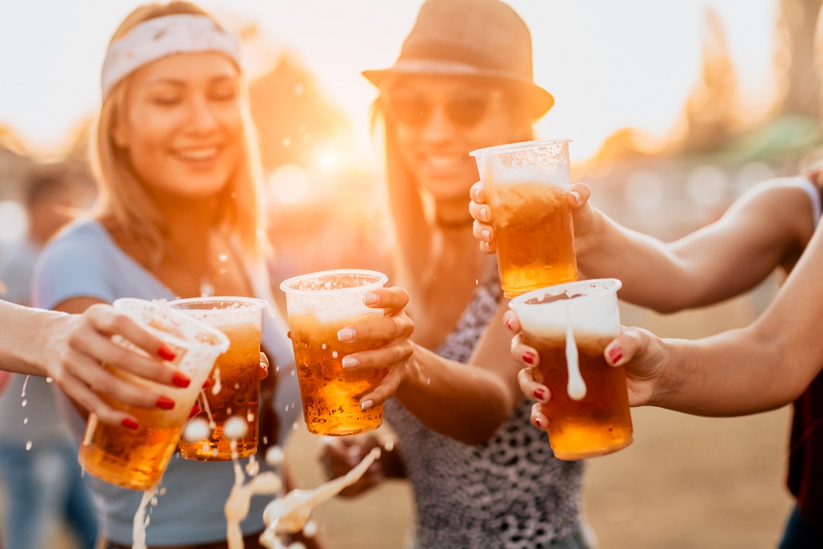 Female,Friends,Cheering,With,Beer,At,Music,Festival