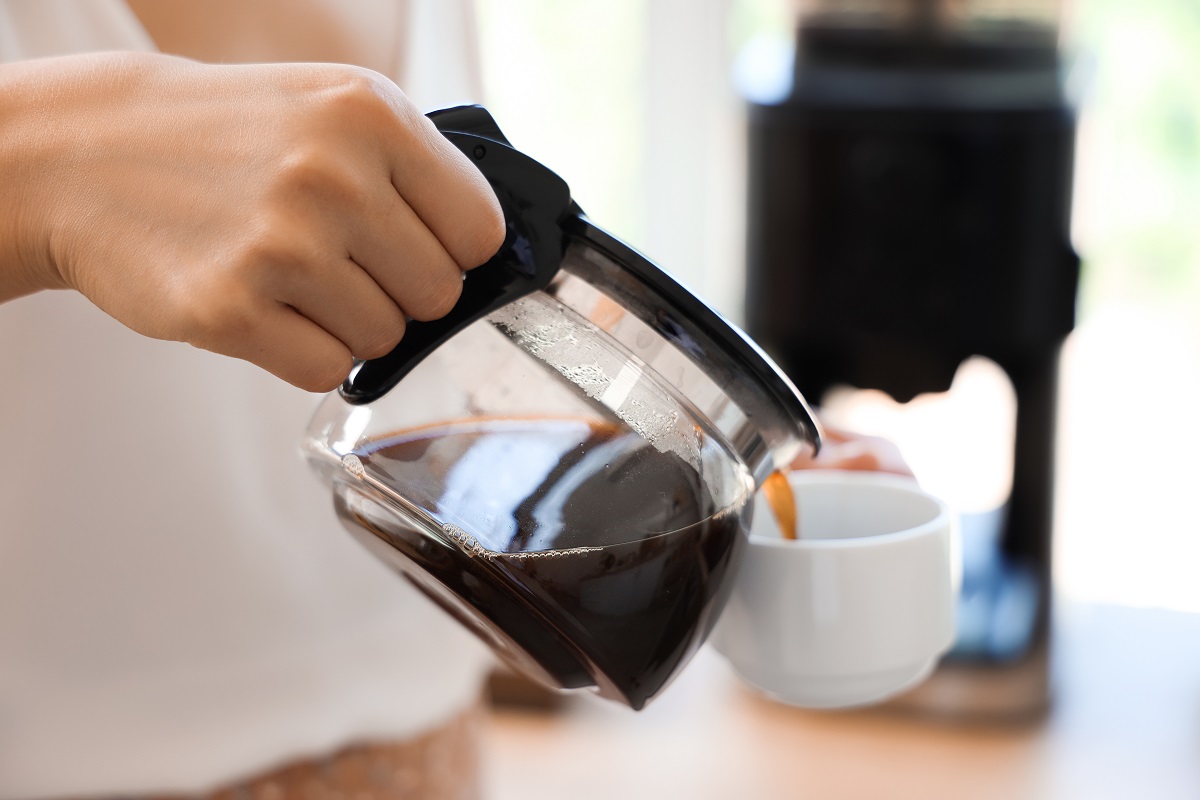 Woman,Pouring,Espresso,From,Pot,Into,Cup,In,Kitchen