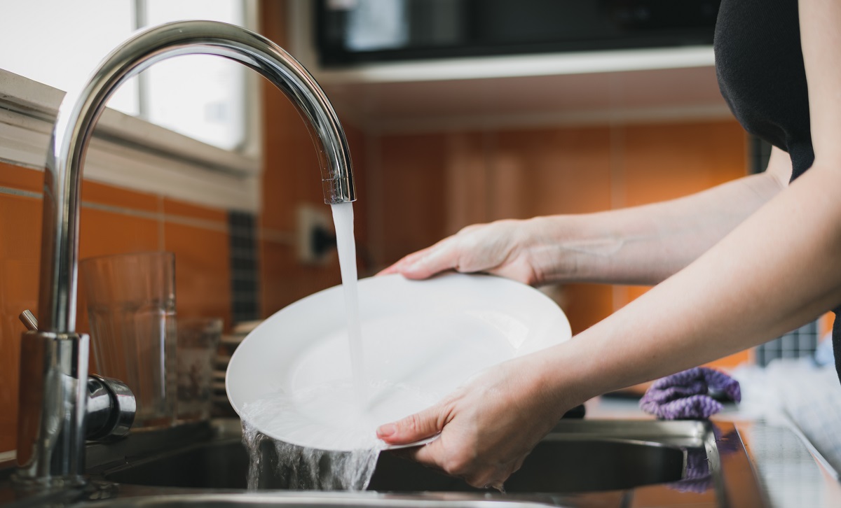 Woman,Washing,Dishes,In,Kitchen,Sink,,Close,Up,Of,Hands