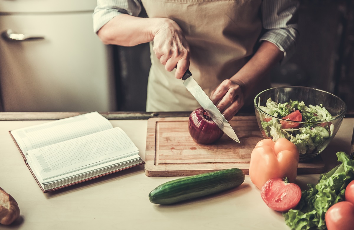 Cropped,Image,Of,Beautiful,Mature,Woman,In,Apron,Cutting,Onion