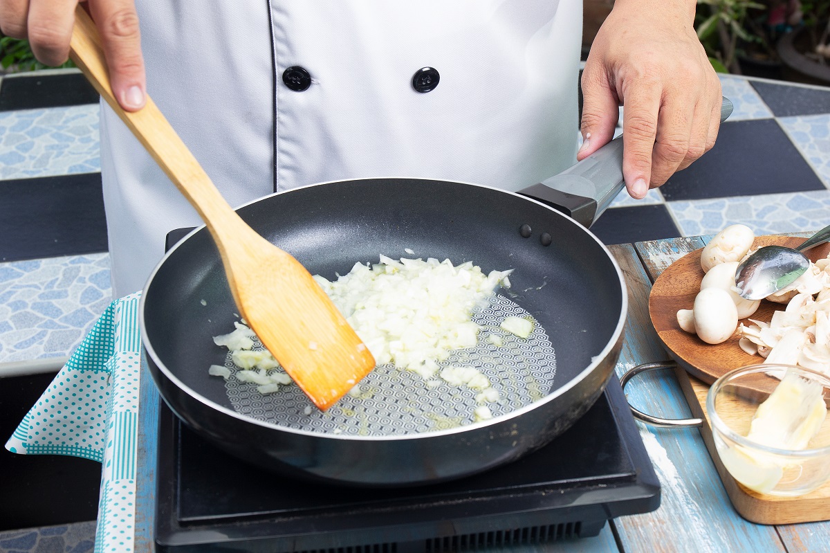 Chef,Stiring,Minced,Onion,In,The,Pan,Prepared,For,Cooking