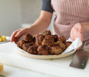 Woman,With,A,Plate,Of,Fresh,Fried,Meatballs,In,The