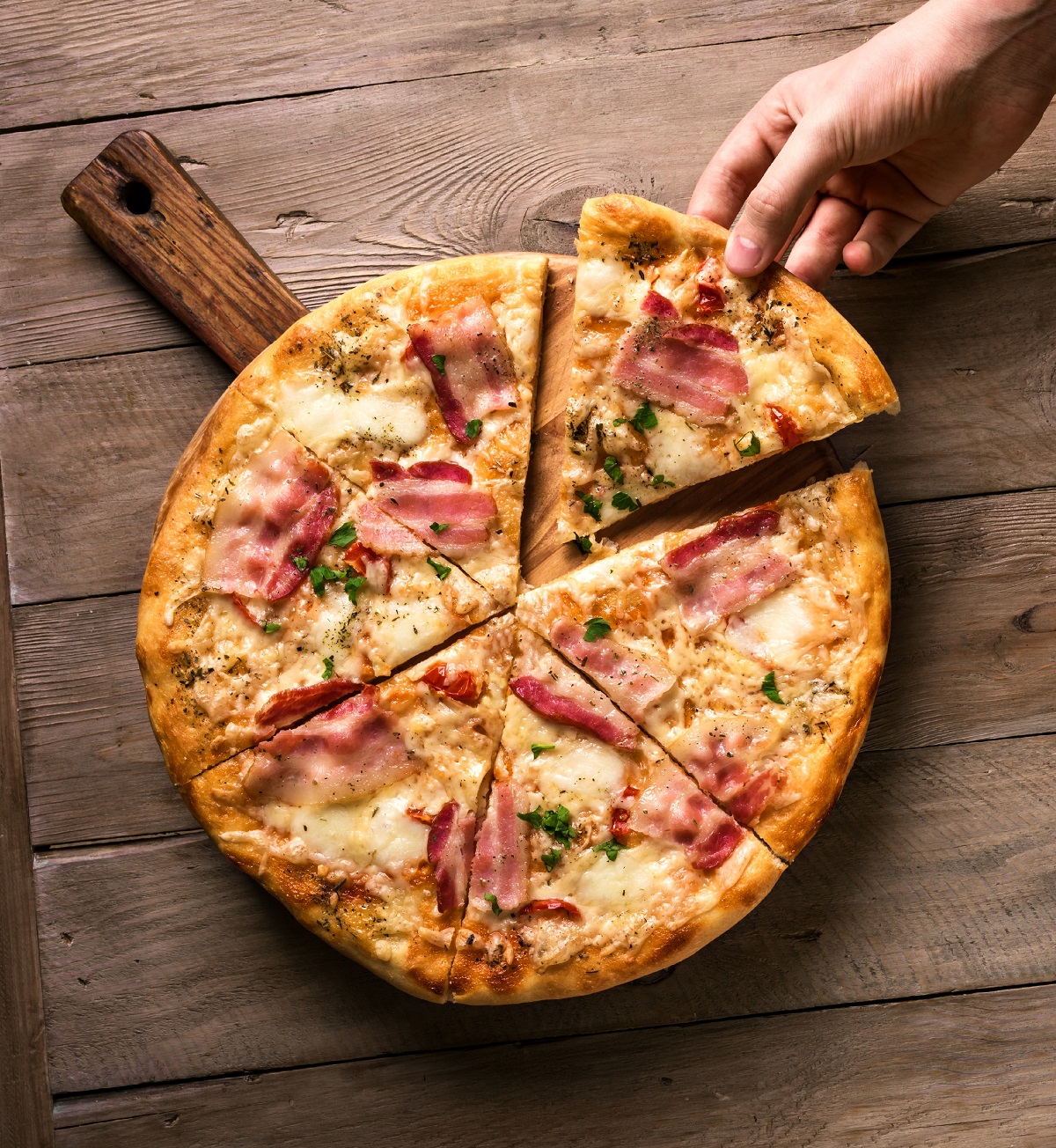 Hand,Picking,Slice,Of,Bacon,Pizza.,Fresh,Homemade,Italian,Bacon