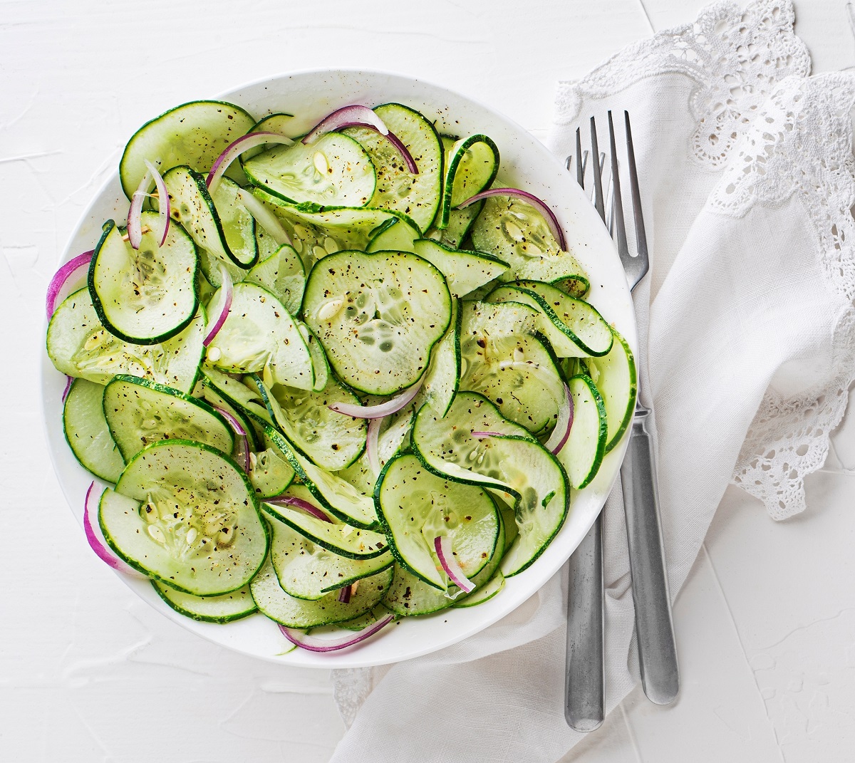 Fresh,Cucumber,Salad,With,Dressing,On,White,Table,Background