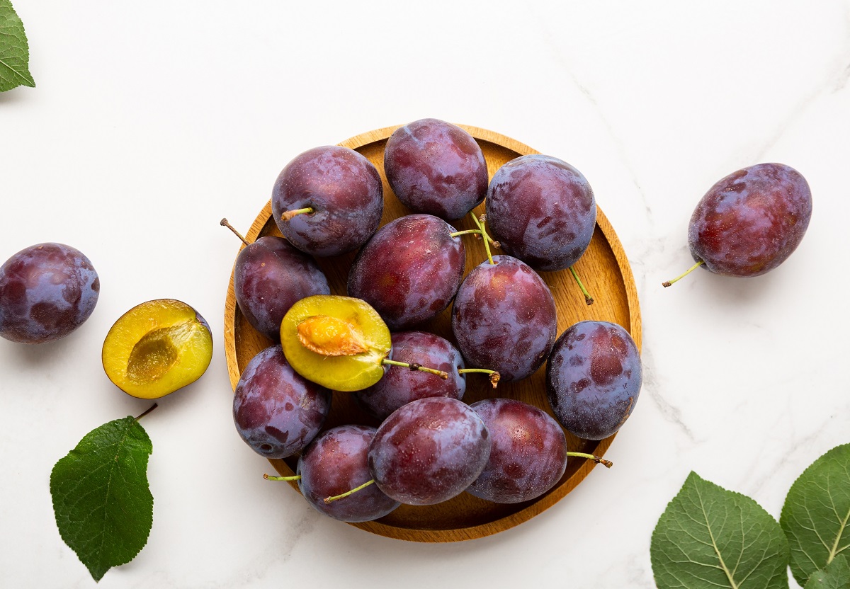 Fresh,Purple,Fruit,Plum,On,Wooden,Plate,Light,Background,Top