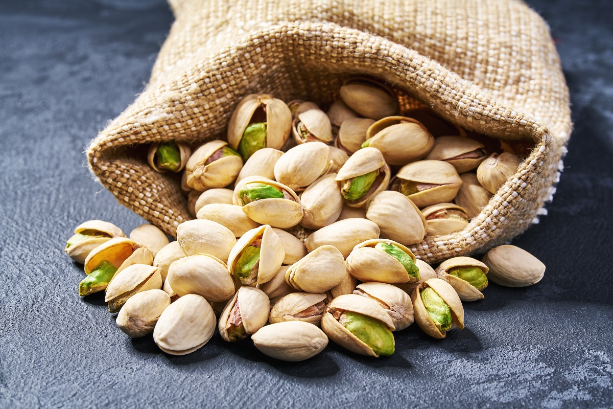 Pistachios,In,Burlap,Sack,On,Wooden,Backdrop.,Heap,Or,Stack