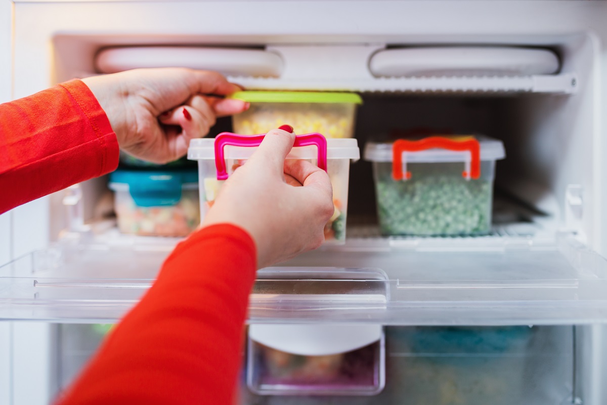 Woman,Placing,Containers,With,Frozen,Vegetables,In,Freezer.