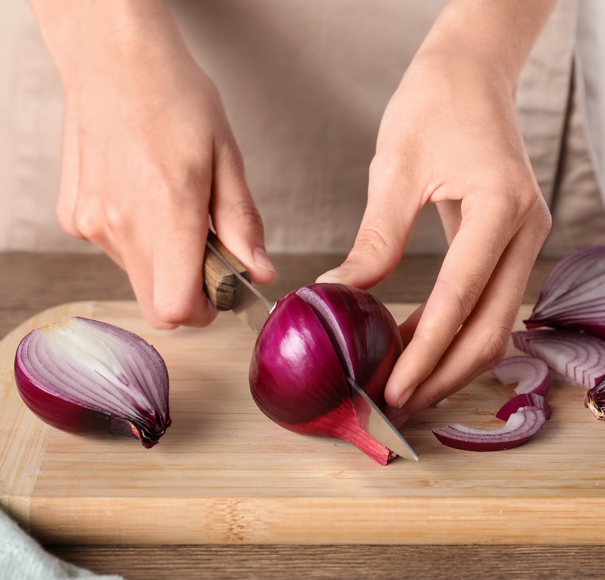 Young,Woman,Cutting,Ripe,Red,Onion,On,Board,At,Wooden