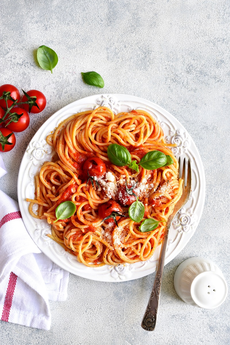 Spaghetti,With,Grilled,Tomatoes,On,A,White,Plate,Over,Light