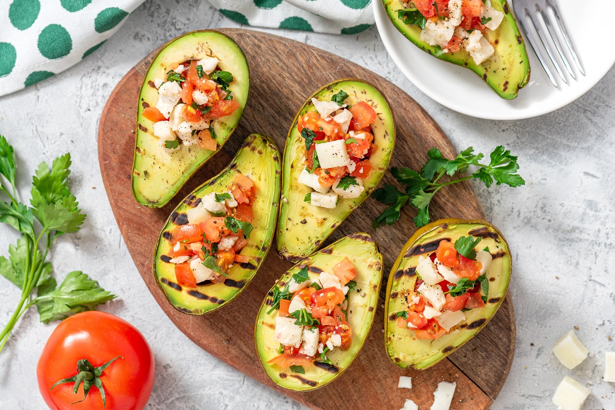 Grilled,Avocado,Stuffed,With,Tomatoes,,Goat,Cheese,,Parsley,,And,Olive