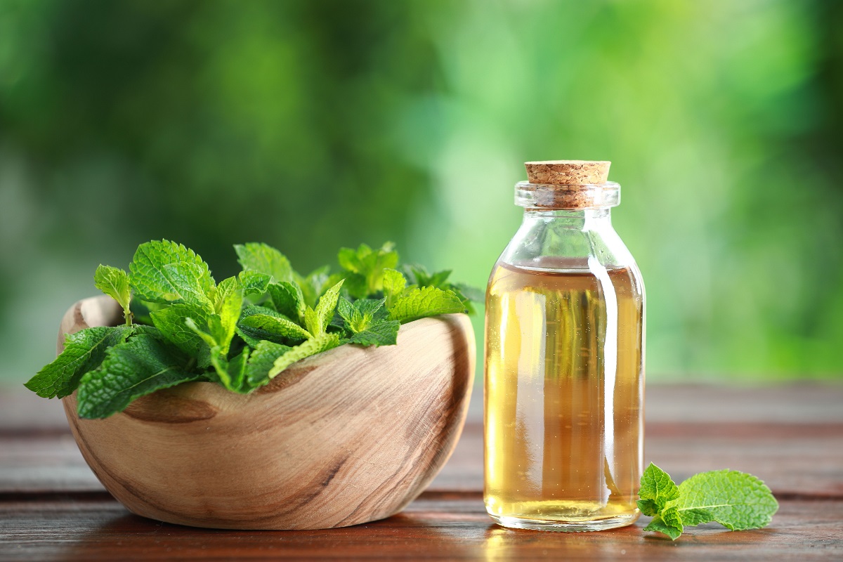 Bottle,Of,Mint,Essential,Oil,And,Fresh,Leaves,On,Wooden