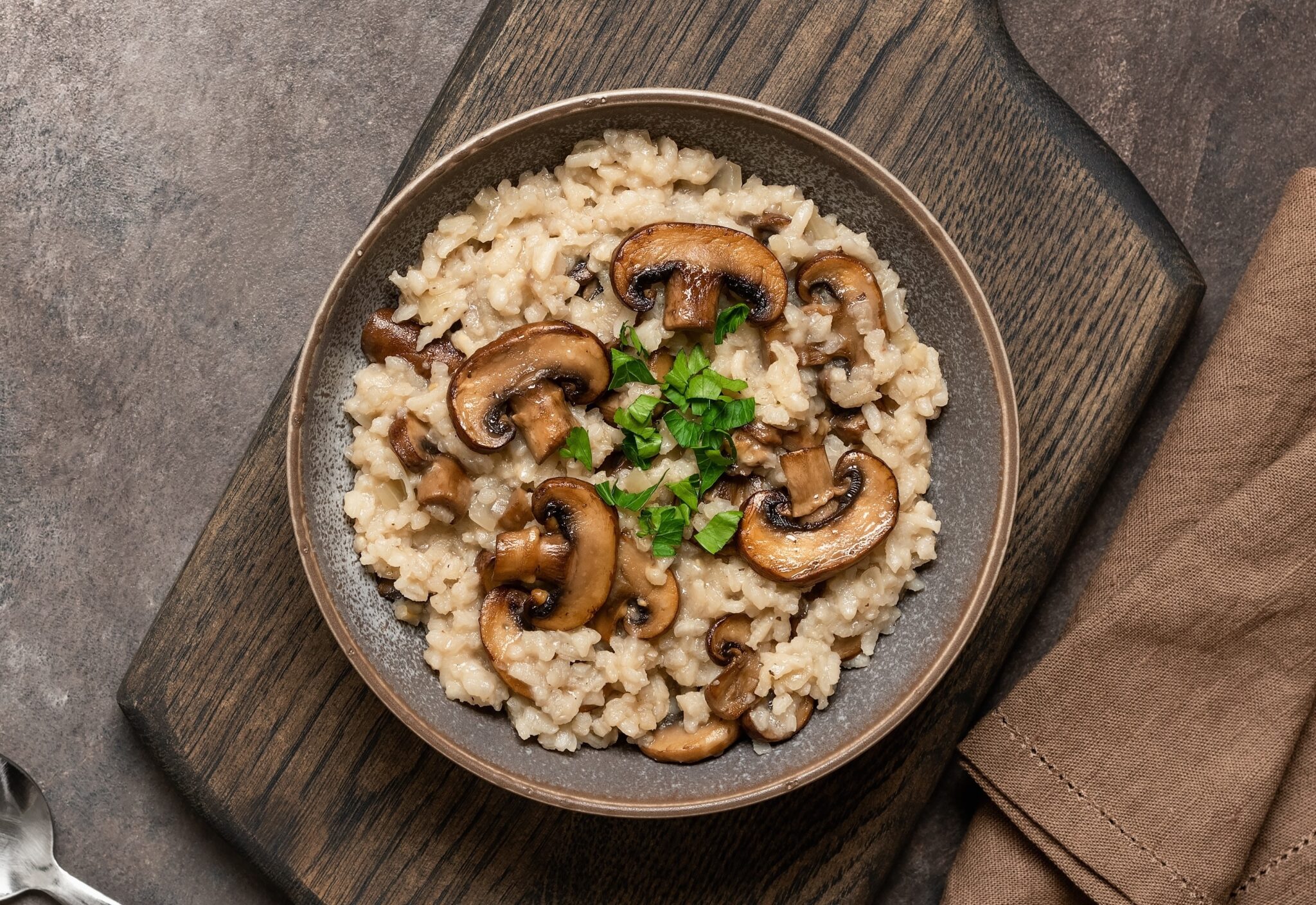 Risotto,With,Mushrooms,In,A,Plate,On,A,Wooden,Cutting