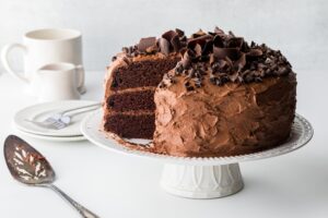 A,Triple,Layered,Chocolate,Cake,With,Slices,Removed,,Against,A