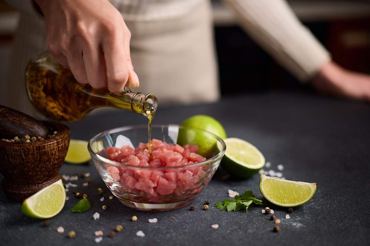 Woman,Pours,Cooking,Olive,Oil,Onto,Sliced,And,Chopped,Tuna