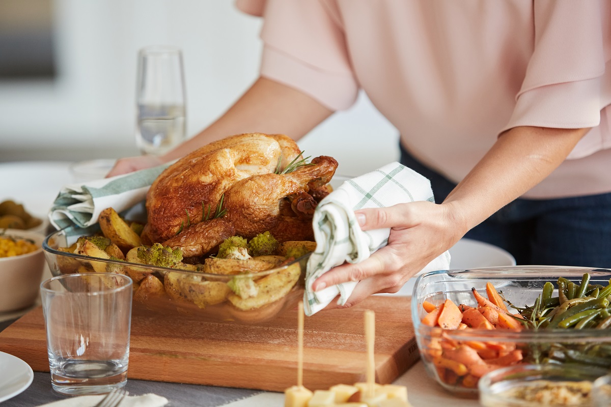 Close-up,Of,Woman,Putting,The,Dish,With,Roast,Turkey,And