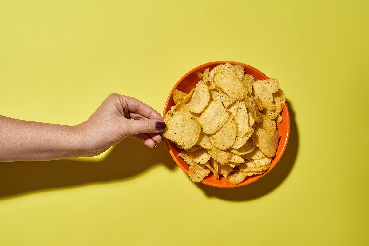 Partial,Female,Hand,Taking,Tasty,And,Appetizing,Potato,Chip,From