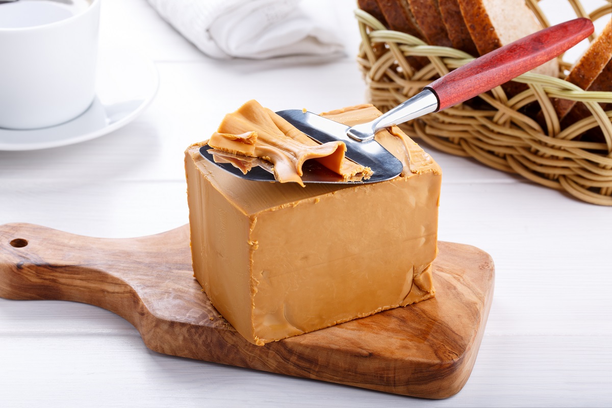 Norwegian,Brunost,On,White,Table.,Traditional,Scandinavian,Brown,Cheese.