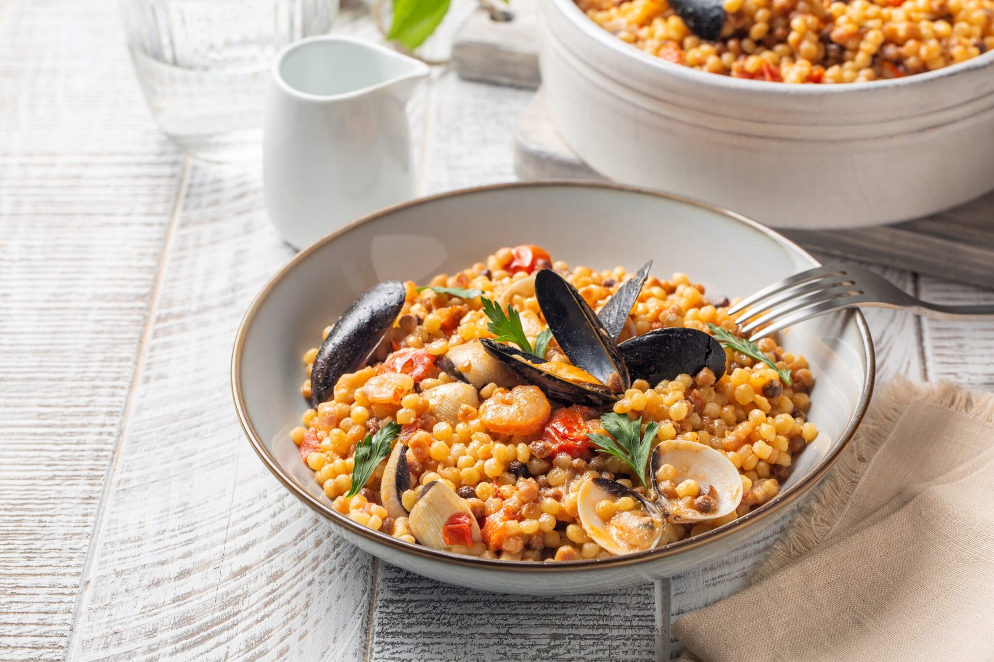 Italian,Pasta.,Fregula,With,Seafood,On,A,White,Wood,Surface.