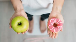 Woman,On,Weight,Scale,And,Hand,Hold,Green,Apple,And