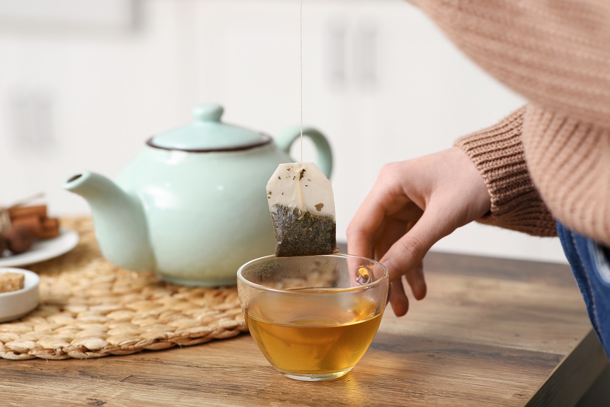 Young,Woman,Making,Tea,With,Tea,Bag,On,Table,In