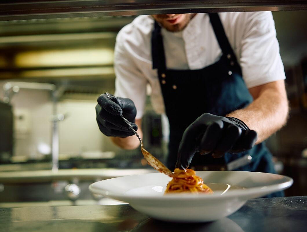 Close,Up,Of,Chef,Serving,Pasta,In,The,Kitchen.