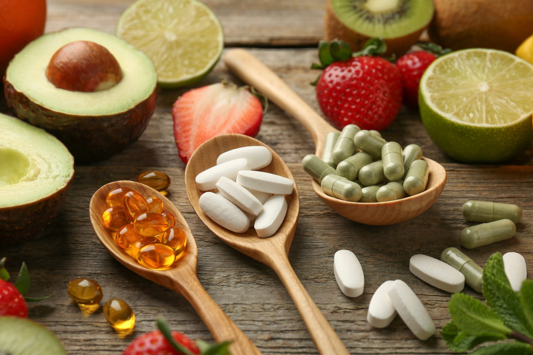 Different,Vitamin,Pills,And,Fresh,Fruits,On,Old,Wooden,Table